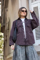 Camisa violeta oscuro con bolsillos con tapa ondulada y puños tableados.