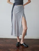 Falda midi gris de microtul con tajo lateral y lazos ajustables.