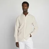 Camisa beige con rayas verticales finas, de corte clásico, manga larga y cuello camisero.