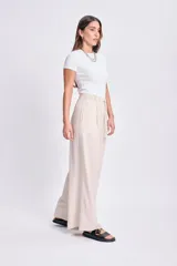 Pantalón de lino color beige, de corte palazzo, con cintura elastizada y cordón ajustable.