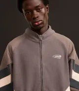 Saco masculino confeccionado en fleece color gris con recortes en marrón y negro, cuello alto, cierre en cremallera, cintura y puños ajustados con elástico. La prenda posee estampa localizada en el pecho con la palabra "LEAGUE".