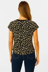 Remera marrón con estampado de ramas, corte holgado y mangas cortas.
