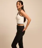 Pantalón boot cut de jeans negro, con bolsillos delanteros y traseros, cierre con botón y cremallera, y trabillas en la cintura.