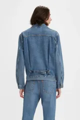 Campera de jean celeste de corte clásico con cuello camisero, cierre frontal con botones metálicos, bolsillos con solapa abotonada en el pecho y bolsillos laterales.