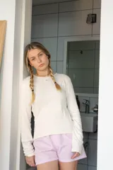 Conjunto de algodón color crudo, compuesto por una remera de manga larga y un pantalón de corte recto.