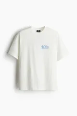 Remera blanca de algodón con cuello redondo y corte holgado. Estampa azul con la palabra 'SYNTHESIS' y texto inferior.
