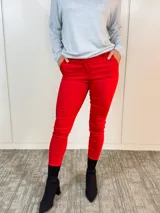 Pantalón de vestir rojo, de corte ajustado, con bolsillos delanteros y falsos bolsillos traseros.