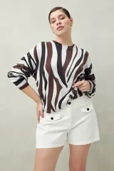 Short blanco de tiro alto con bolsillos delanteros con solapa y botones a la vista.