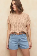 Chaleco tejido color beige con diseño calado, cuello redondo y mangas cortas.