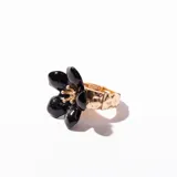 Anillo dorado con aplique de flor negra.