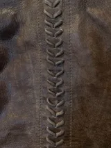 Top de cuero color marrón con escote en V y tirantes finos trenzados. Cuenta con un detalle vertical de pasamanería artesanal bordada a mano en el frente y cierre con broches en la espalda.