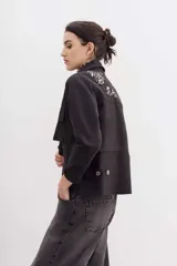 Campera verde militar de gabardina de algodón con corte holgado y cordón de ajuste en la cintura. Decorada con bordados de piedras en los hombros.