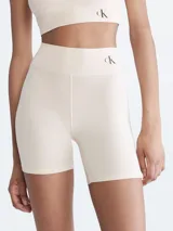 Shorts de ciclismo color beige, de tiro alto, con logo de Calvin Klein en la cintura.