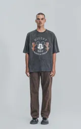 Remera negra con efecto gastado, cuello redondo y mangas cortas. Estampado frontal con Mickey Mouse, tigres y texto en inglés y chino.