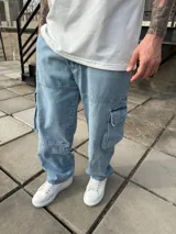 Pantalón cargo celeste de jean, corte baggy, con bolsillos laterales con solapa y bolsillos traseros.