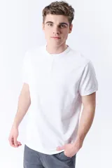 Remera de manga corta de piqué color blanco, con cuello mao y botonera parcial.