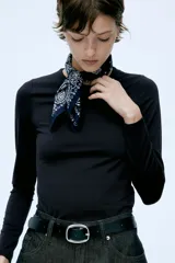 Remera negra de punto elástico, de corte ajustado, con cuello redondo y mangas largas.