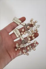 Aros colgantes con base plateada con strass y cuentas de perlas color crema y blancas.