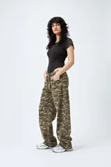 Pantalón de tiro bajo con estampado camuflado, confeccionado en tela liviana de calce amplio. Su diseño incorpora cintura regulable con cordón y bolsillos utilitarios.