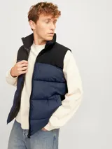 Chaleco acolchado azul marino y negro, sin mangas, con cuello alto y cierre de cremallera.