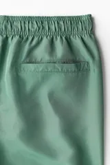 Short de baño verde con elástico y cordón ajustable en la cintura, bolsillos laterales y trasero con cierre autoadherente.