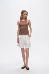 Musculosa blanca sin mangas, ajustada al cuerpo y con cuello redondo.