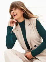 Chaleco negro con solapas cruzadas, doble botonadura, bolsillos laterales y lazo para atar en la cintura.