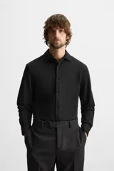 Camisa azul marino slim fit de manga larga con cuello italiano abierto y cierre frontal con botones.
