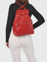 Mochila de cuero color negro con cierre de solapa con botón a presión y bolsillo frontal con cierre de cremallera.