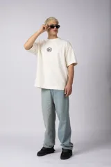 Remera negra oversize de algodón premium con cuello redondo y mangas cortas. Presenta un logo bordado en el frente y un parche estampado en la espalda.