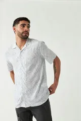 Camisa estampada de hombre, corte slim, manga corta, cartera abotonada y logo bordado.