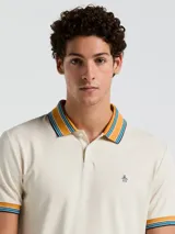 Polo manga corta color crema con cuello y puños a rayas en tonos azul y naranja.