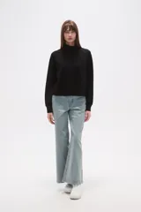 Buzo negro de manga larga con cuello tortuga y corte holgado.