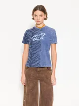 Remera azul con efecto lavado, manga corta y cuello redondo. Presenta un diseño de dos paneles, uno liso y otro con estampado animal print. Estampa frontal con la frase "lucky chili".