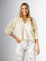 Blusa color amarillo pálido de algodón, con cuello mao y mangas 3/4 abullonadas con volados.