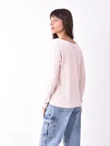 Remera color gris claro de manga larga con escote en V y botones.