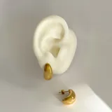 Par de caravanas doradas con forma de gota, de acero quirúrgico hipoalergénico con baño en oro 18K.