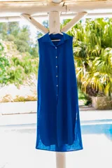 Camisola roja tipo vestido camisero, de corte midi, con cuello camisero, abotonada al frente y con abertura en el ruedo.