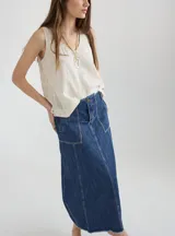 Falda larga de jean azul con bolsillos frontales y ruedo desflecado.