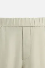Pantalón negro regular fit confeccionado en tejido de lino. Cintura ajustable con cordón interior, bolsillos frontales y detalle de bolsillos traseros de vivo.