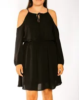 Vestido corto negro con hombros descubiertos y mangas largas.