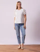 Remera blanca de cuello redondo y mangas cortas abullonadas de microtul bordado con puño elastizado.