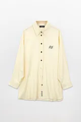 Camisa color crema de lino con botones y bordados a contratono.