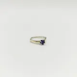 Anillo solitario en plata y oro con circonia violeta redonda engarzada.