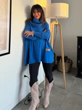 Polerón celeste oversize con cuello alto, mangas largas con puños acanalados y detalle de etiqueta de cuero en el frente.