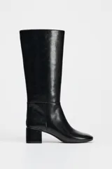 Bota negra de caña media de cuero sintético, con punta redonda y tacón ancho.