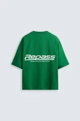 Camiseta verde con corte holgado, cuello redondo y mangas cortas. Presenta una banda horizontal en el pecho y la espalda con tejido de red. Estampados combinados a contraste en el frente.