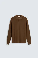 Polo marrón de corte relaxed fit, tejido en punto de algodón. Tiene cuello solapa con cierre frontal de botonadura, manga larga y acabados en rib.