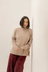 Sweater polera negro de tejido de punto acanalado, con diseño suelto y cuello alto para mayor abrigo.
