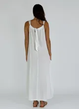 Vestido largo color beige, de corte suelto, sin mangas y con cuello redondo.